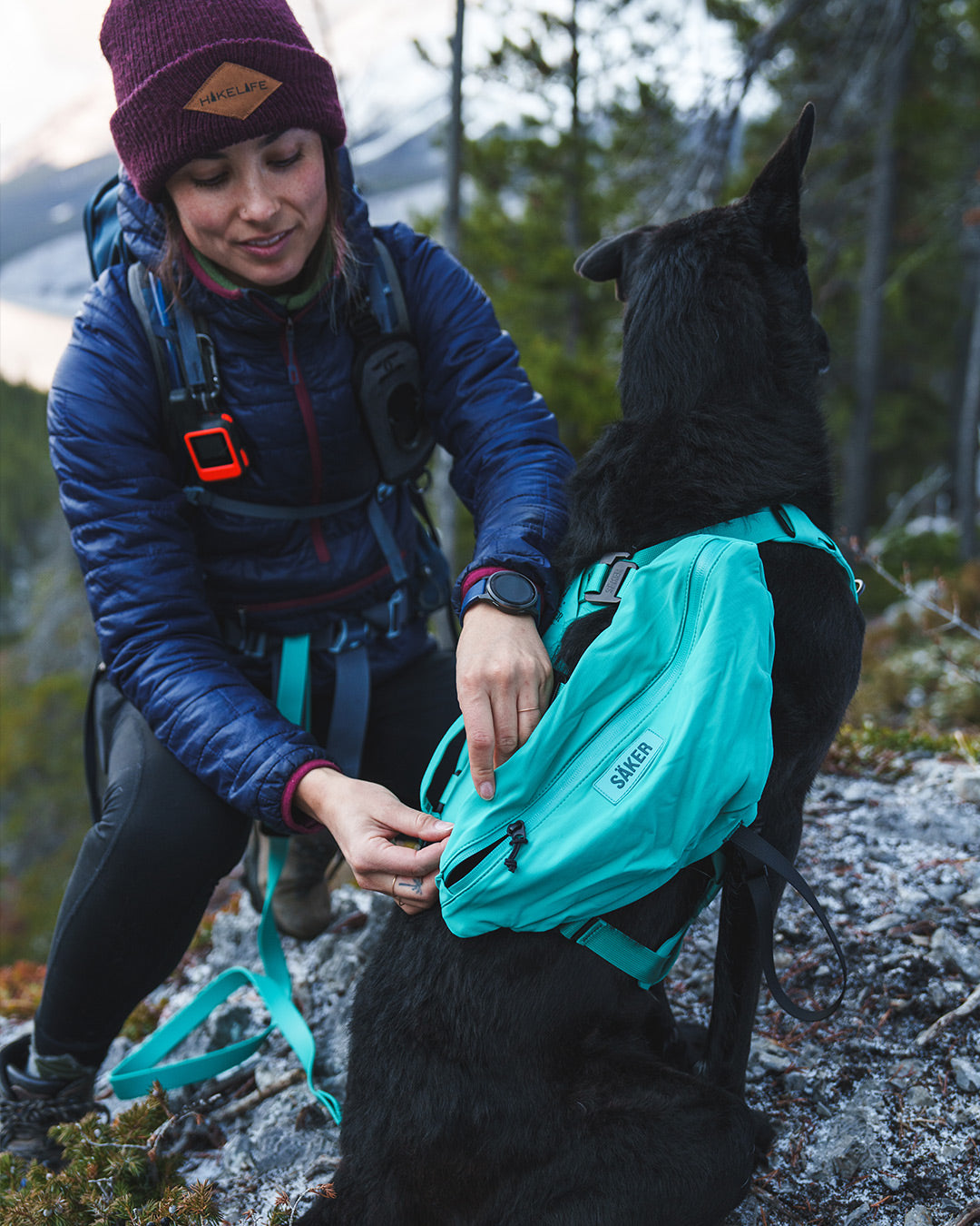 Woman on a hike installing the Pouches 001 on a Lander harness in Skeena Teal color
