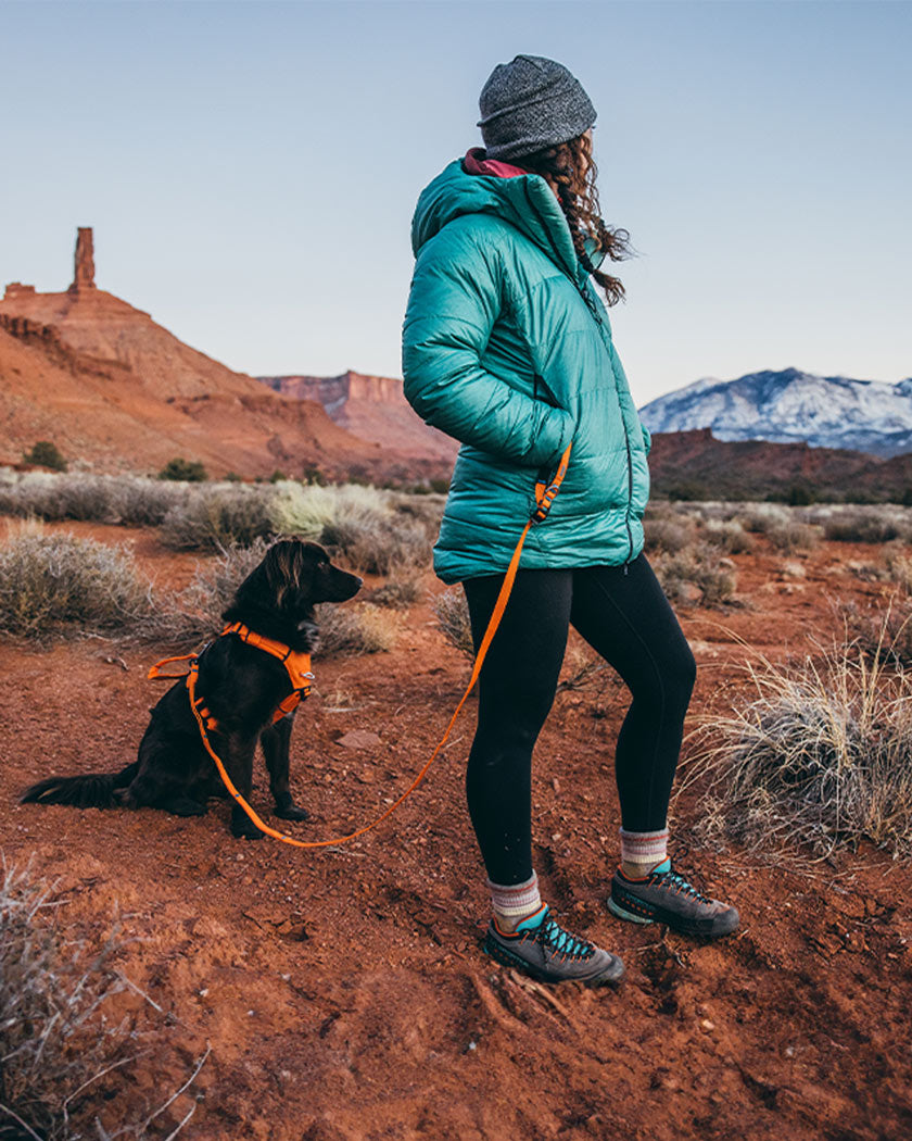 woman holding canyon leash with her dog wearing the canyon light medium in Outback Orange
