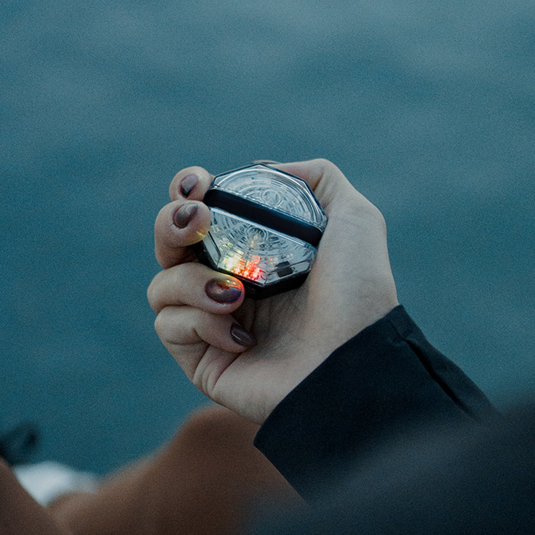 Woman holidng the pitchblack night light 2.0 showing the charge indicator LEDs