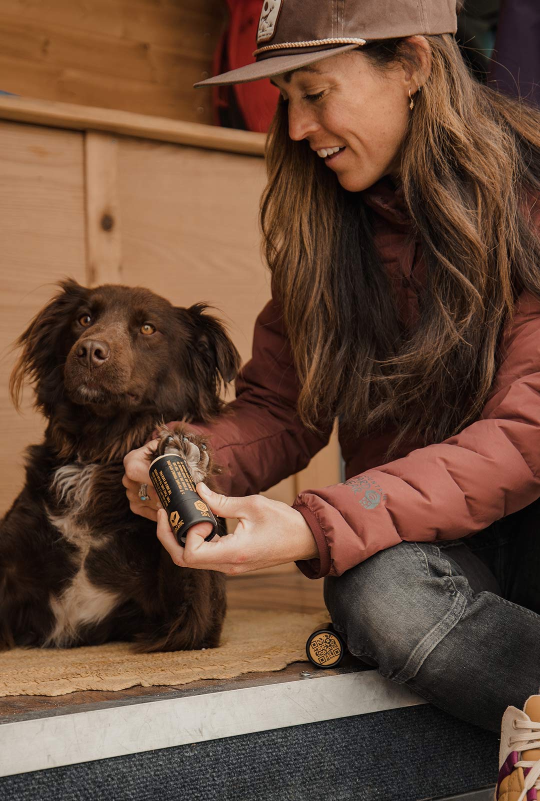 Woman applying Säker paw balm to her dog in her van