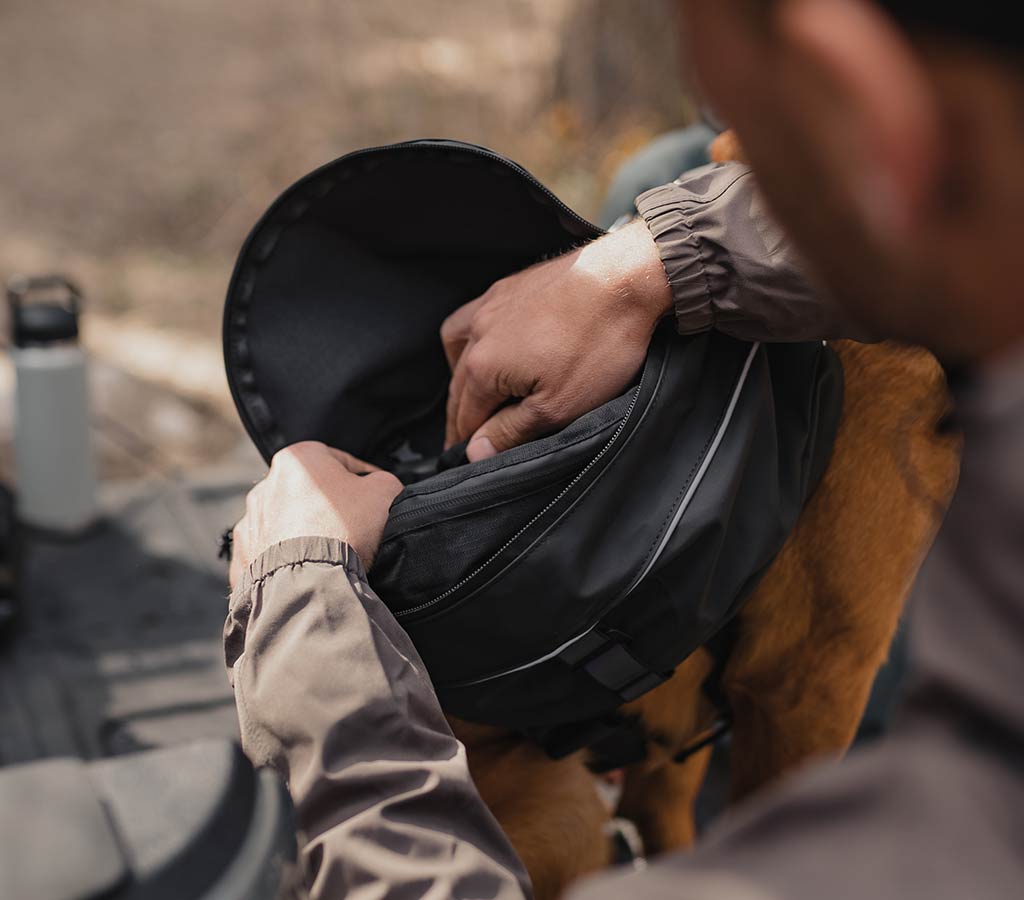 Packing the K-911 rescue sling inside the pouches of the ascension dog pack in the trunk of a jeep gladiator