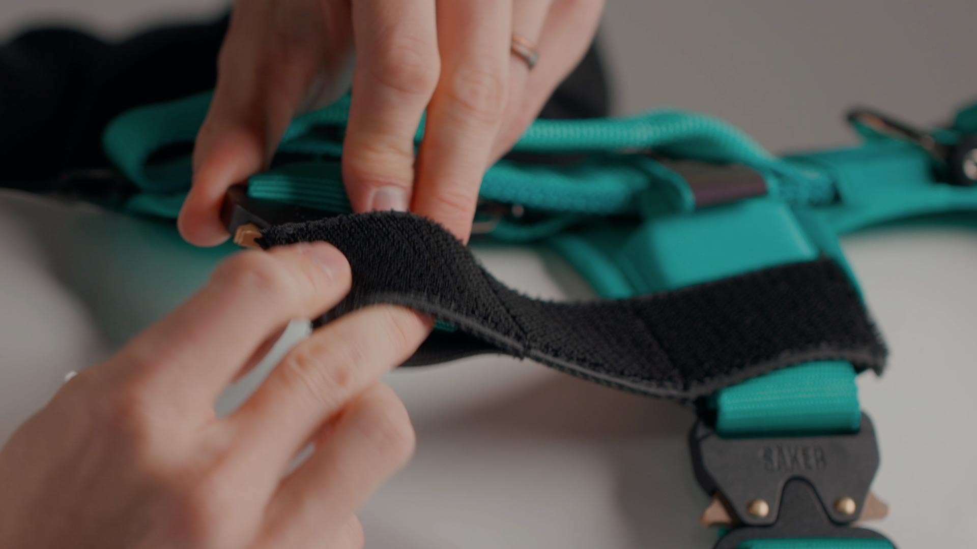 close view of hands installing the velcro sleeves onto the Extended Ascension harness
