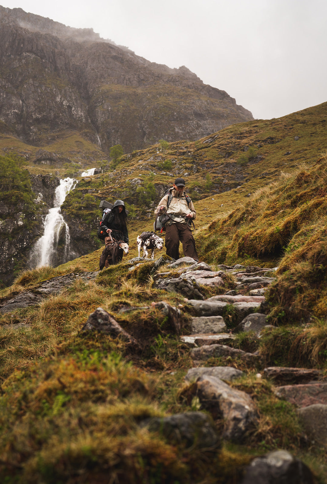 Couple hiking in scotland with their dogs wearing the Säker espresso collection