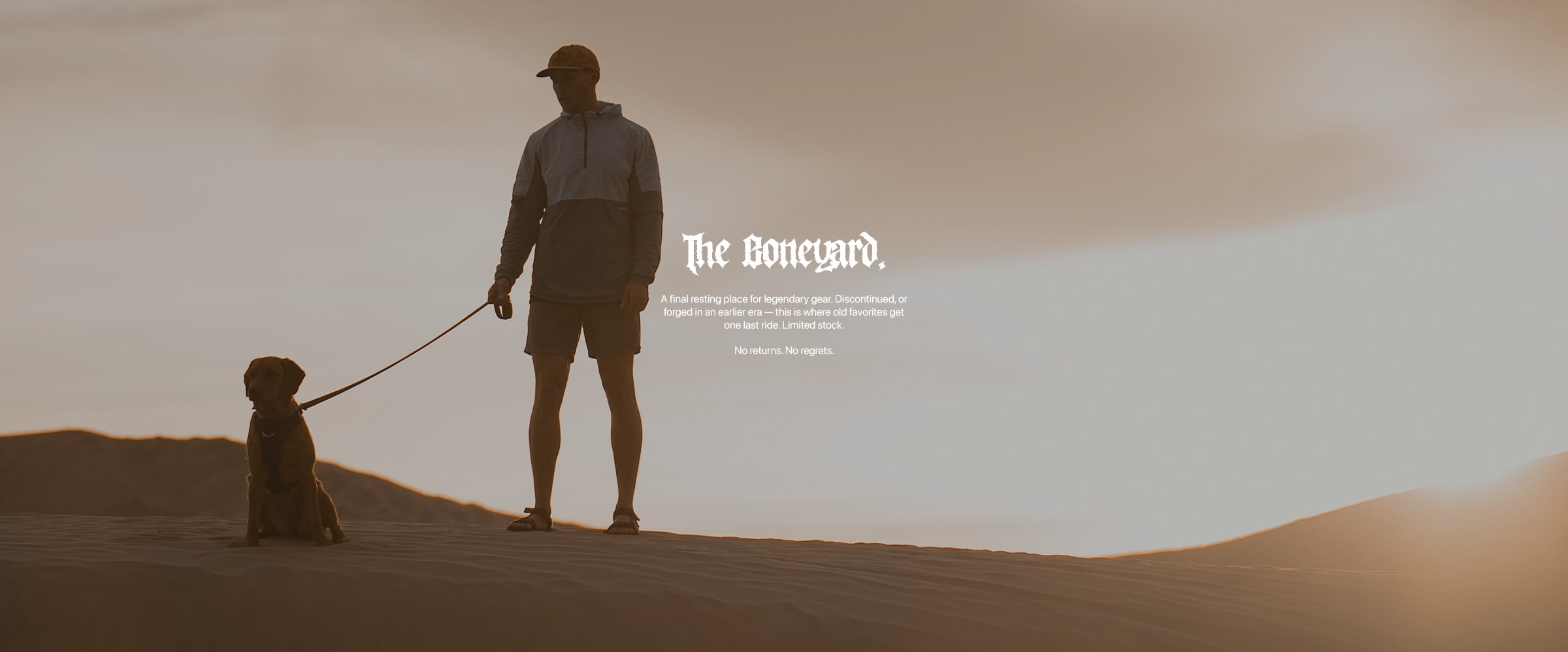 Man holding his dog in the desert wearing Saker gear