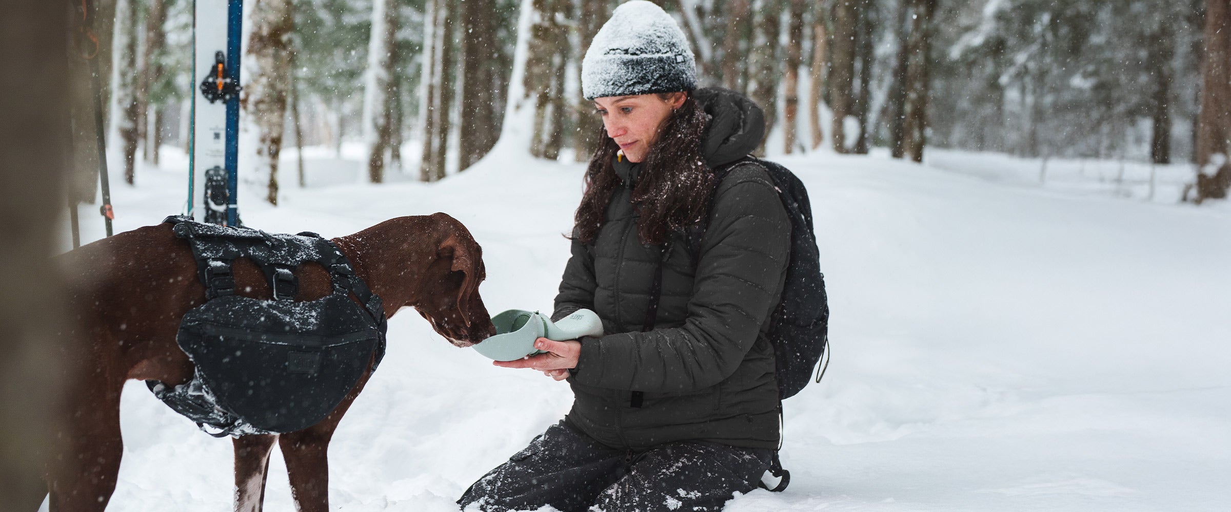 Woman giving water to her dog with the Slurpy Sack 2.0