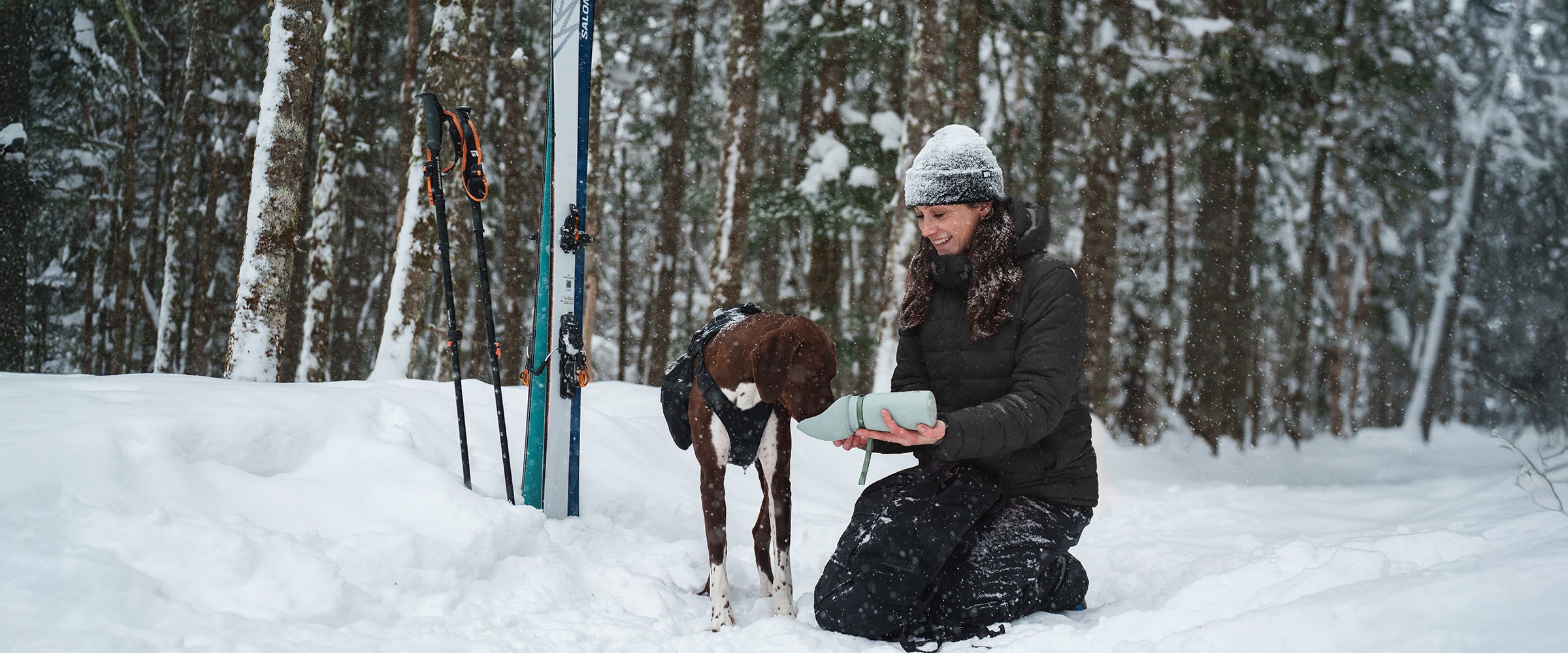 Woman giving water to her dog in the Slurpy Sack 2.0