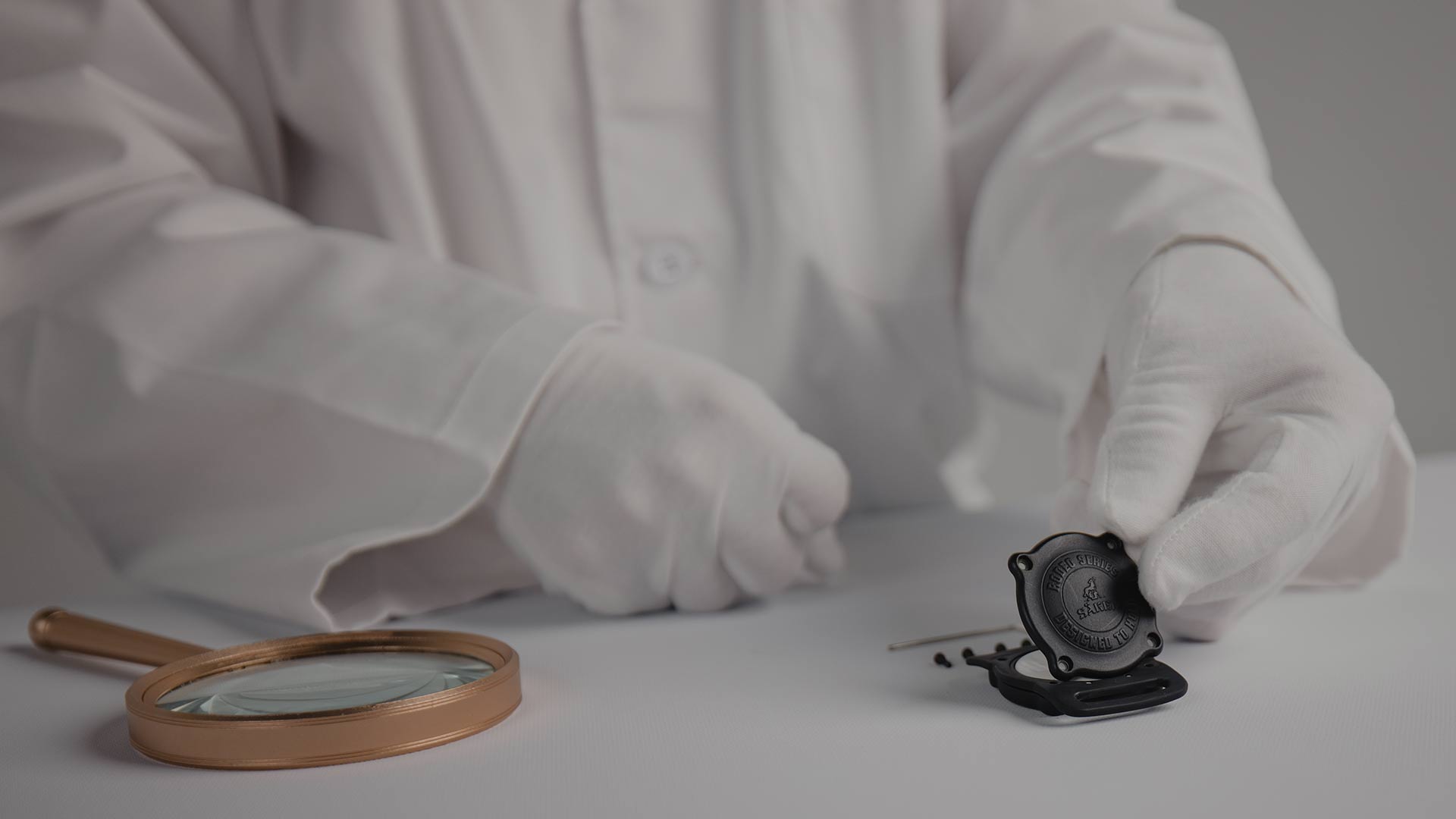 Assembling the Rodeo AirTag Holder on a white table with a white coat