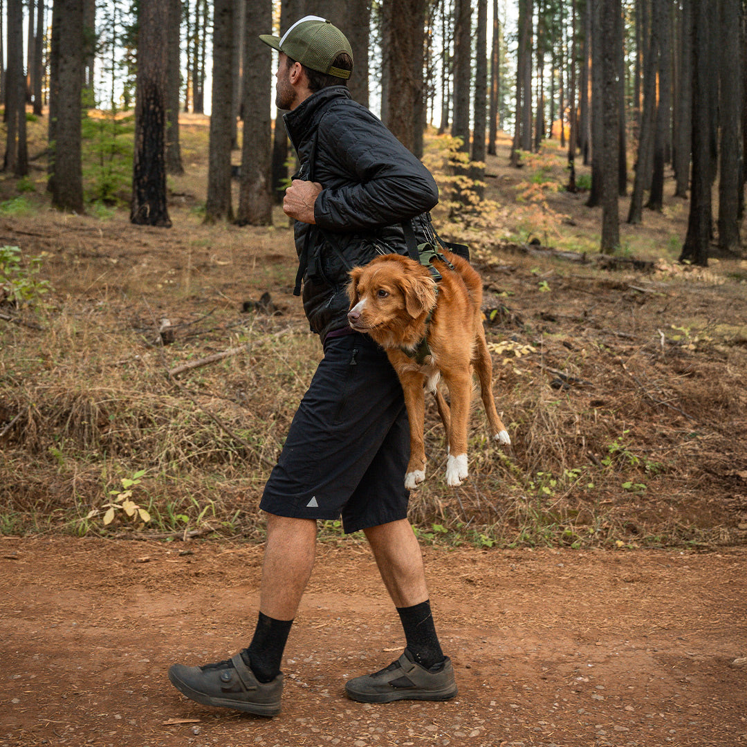 Mountain Biker carrying his injured toller with the Rescue Sling and the Muse harness