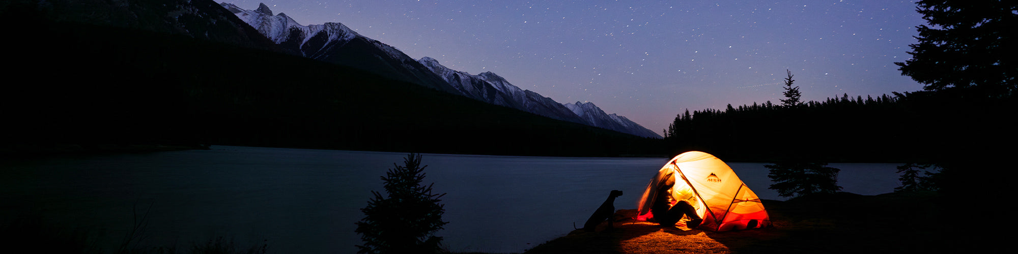 Woman in her tent at night in Banff with her dog for Säker photoshoot
