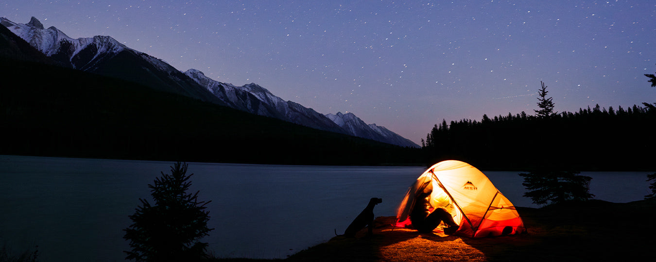 Woman in her tent at night in Banff with her dog for Säker photoshoot