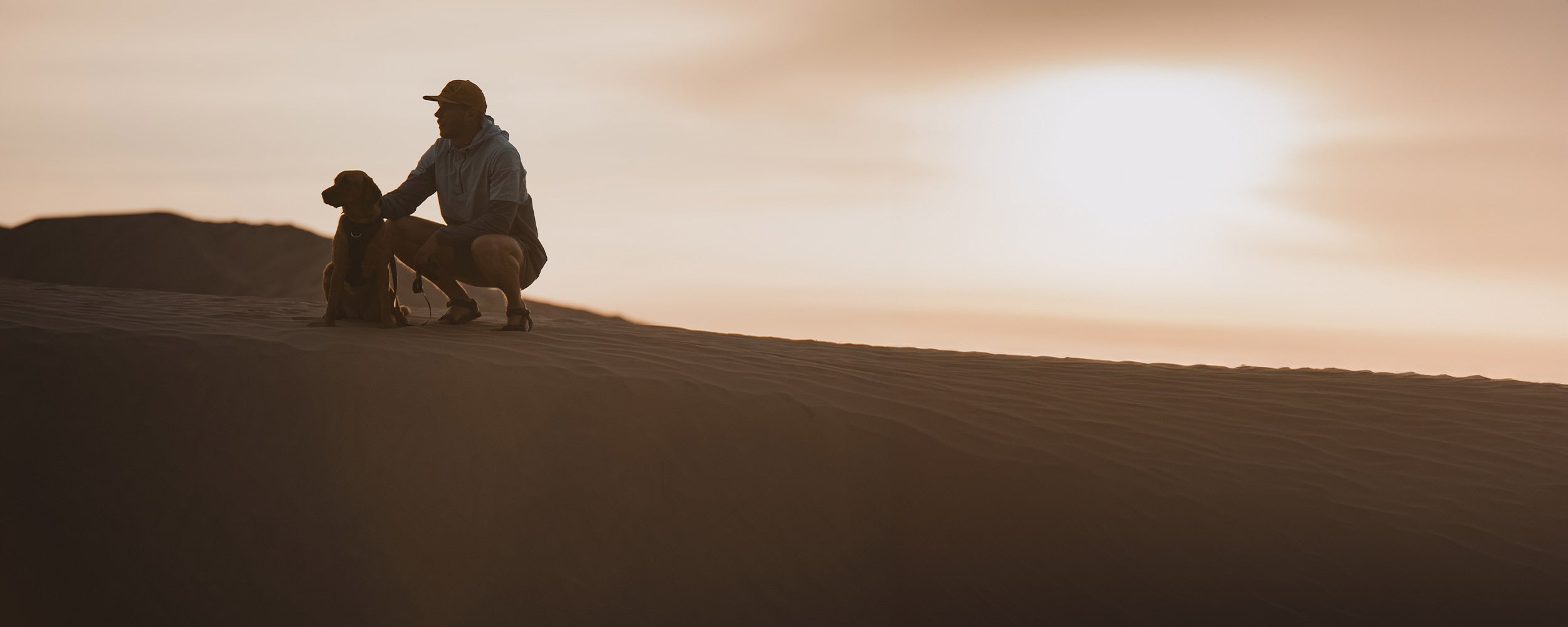 Man next to his dog in the sahara desert wearing the Ascension original prototype