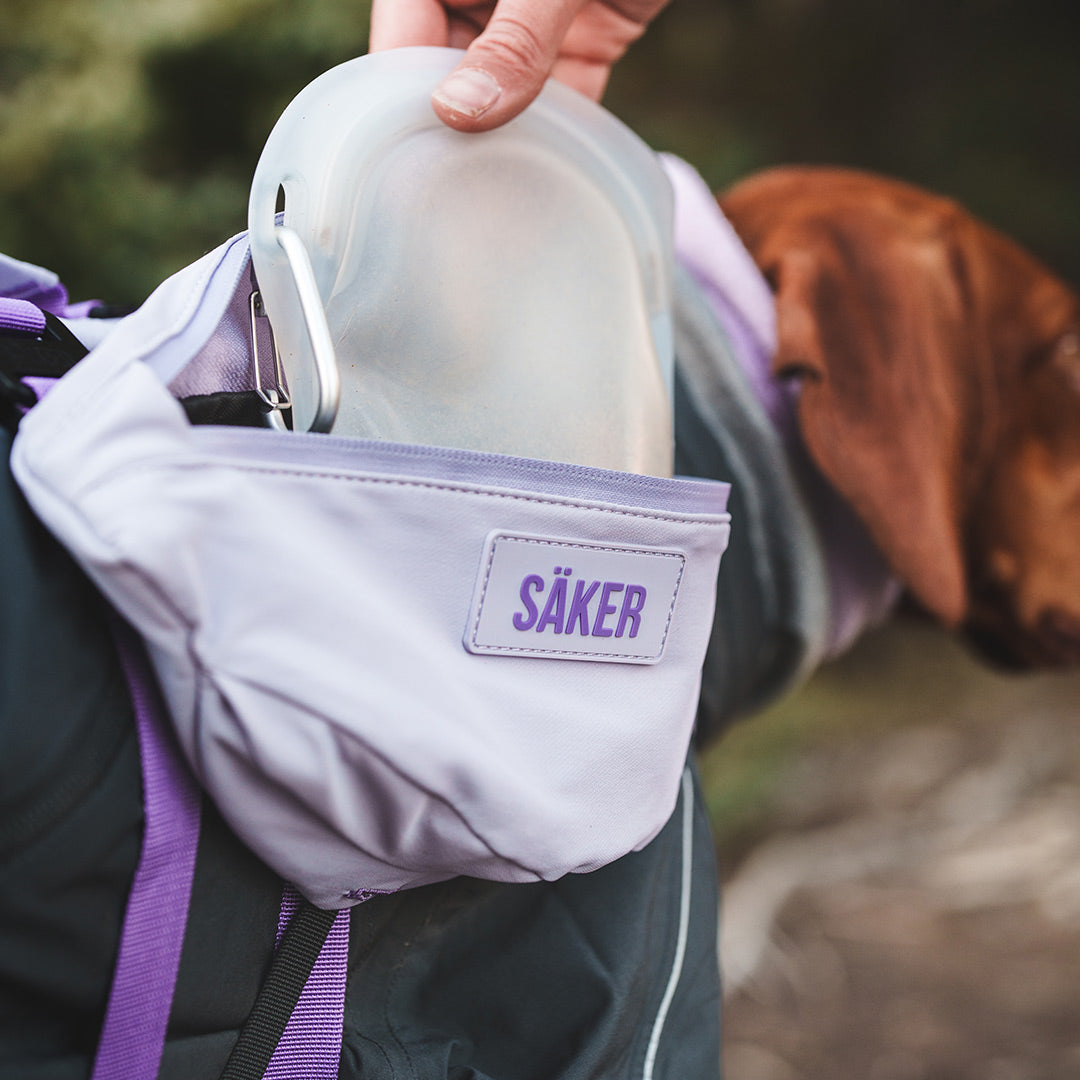 Woman picking a treat bag from inside the Pouches 001 on her vizsla