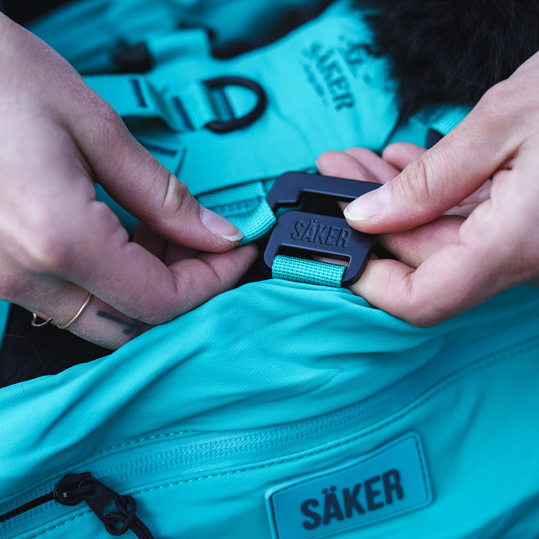 Close view of a woman attacing the Pouches 001 on the Muse harness in Skeena teal